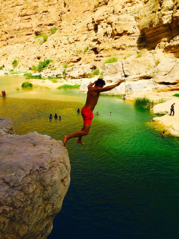 Jumping off a cliff in Wadi Shab, Oman