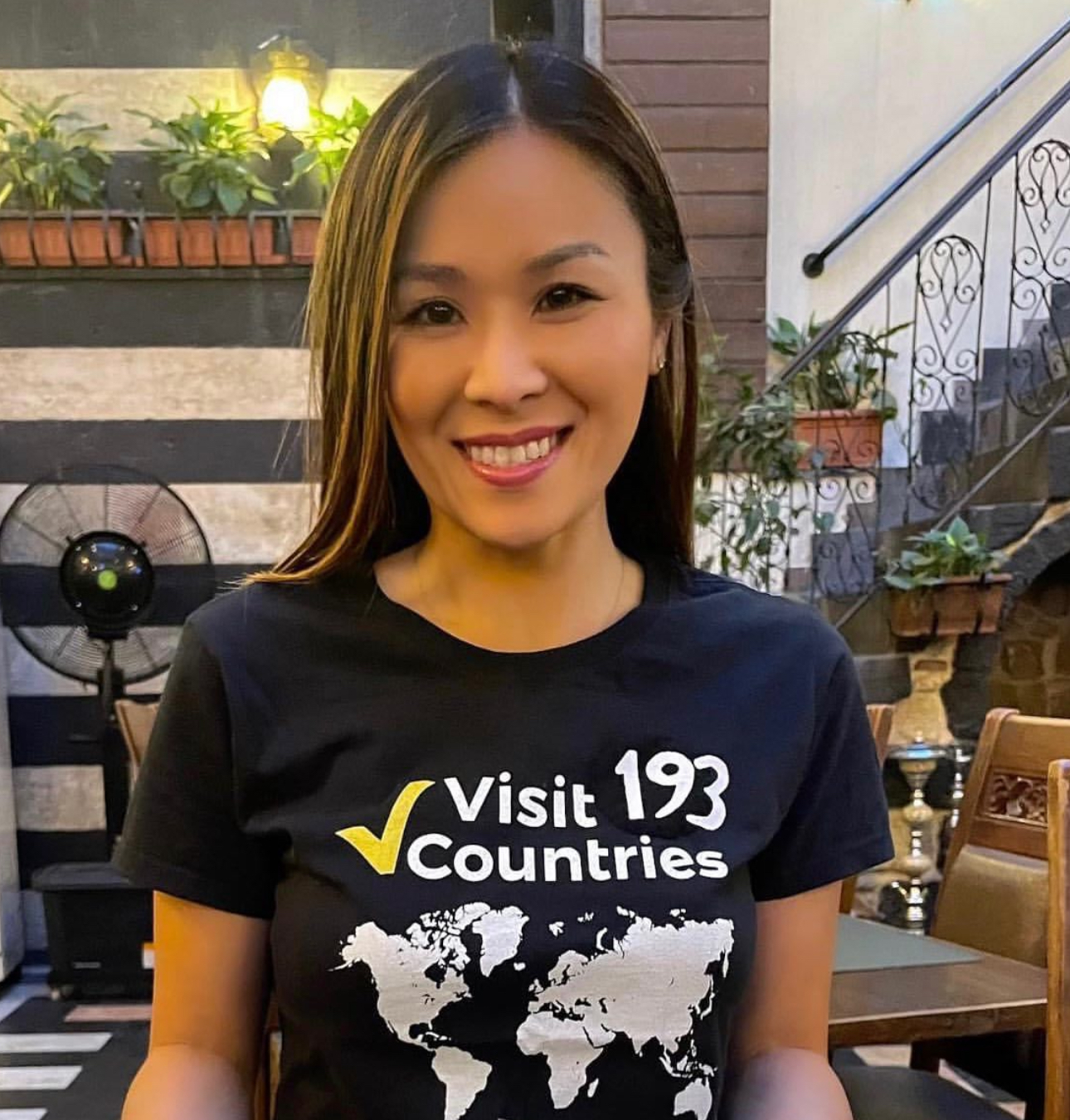 A picture of Lucy Hsu, one of 52 women who have been to every country in the world, wearing a T-shirt stating that she visited all 193 UN countries