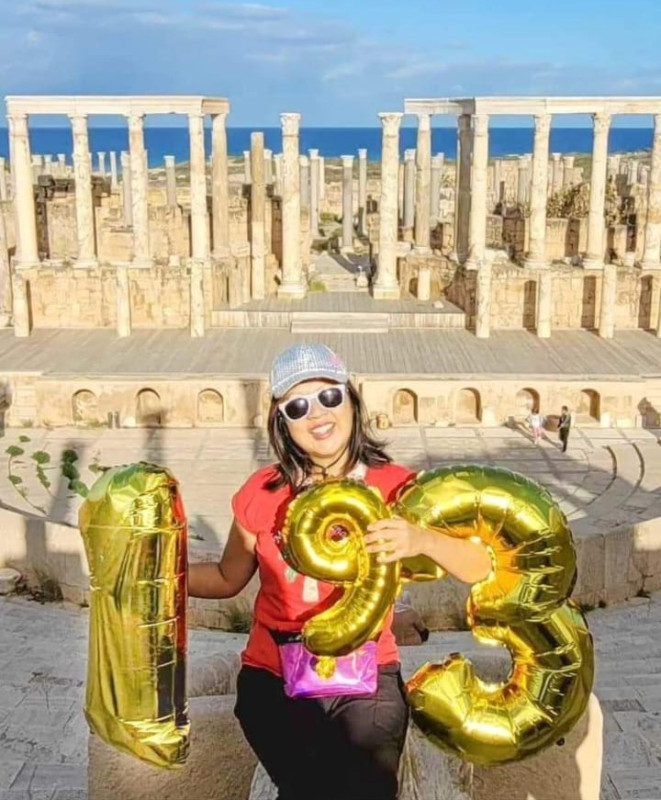 Ernestine Chan in Libya, holding 3 golden baloons with 1, 9 and 3 as she finished visiting all the UN 193 countries