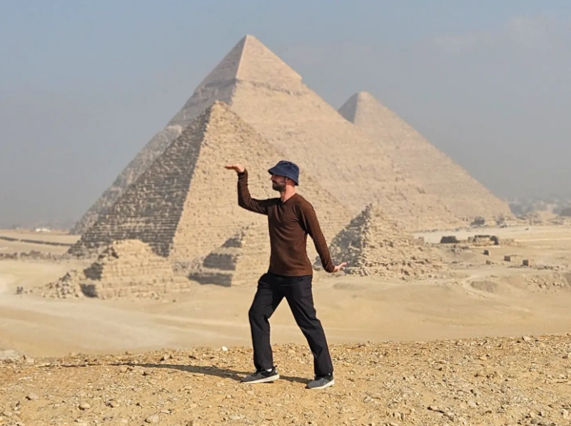 Egyptian traveller Omar Nok posing in front of pyramids in Giza