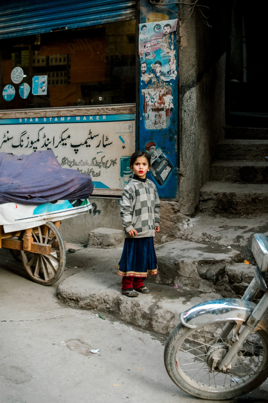 A picture of a little Pakistani girl wearing a lipstick posing on streets of Peshawar, taken by Rasha Yousif