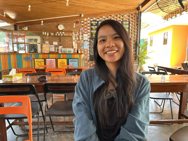 Sabrina, Chinese solo female traveller smiling and posing in the coffee shop in Myanmar