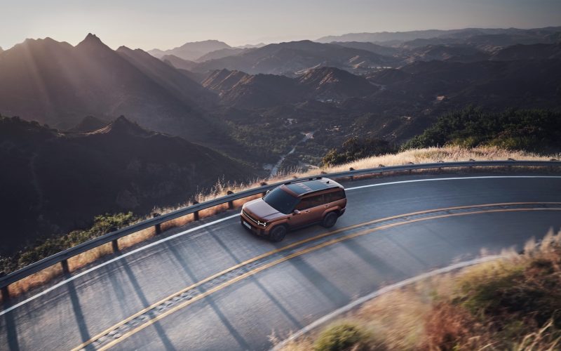 A rugged SUV driving along a scenic mountain highlighting the adventurous capabilities of overlanding vehicles used by overlanders.