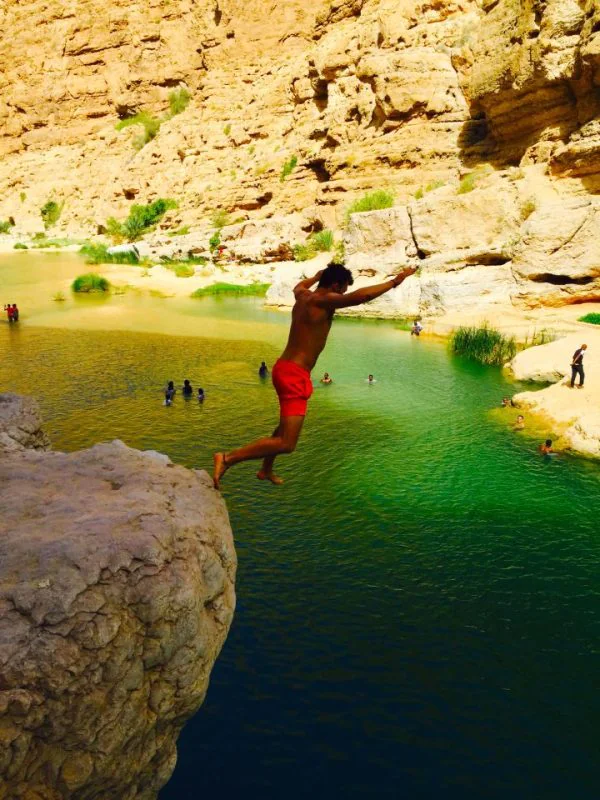 Jumping off a cliff in Wadi Shab, Oman