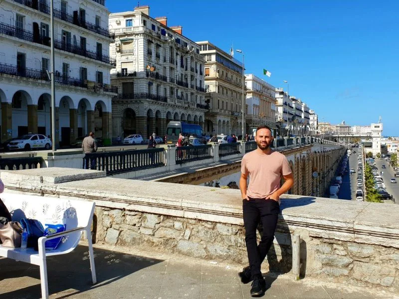 Mike Richards, author of 'The Travelling Ape,' explores the vibrant city of Algiers, Algeria. In this image, he immerses himself in the rich cultural tapestry of Algiers, capturing the essence of his adventurous journey.