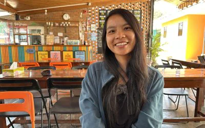 Sabrina, Chinese solo female traveller smiling and posing in the coffee shop in Myanmar